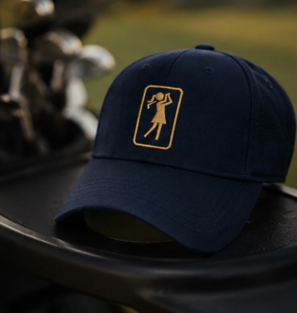 Aurora Midnight golf hat resting on a golf bag with clubs in the background